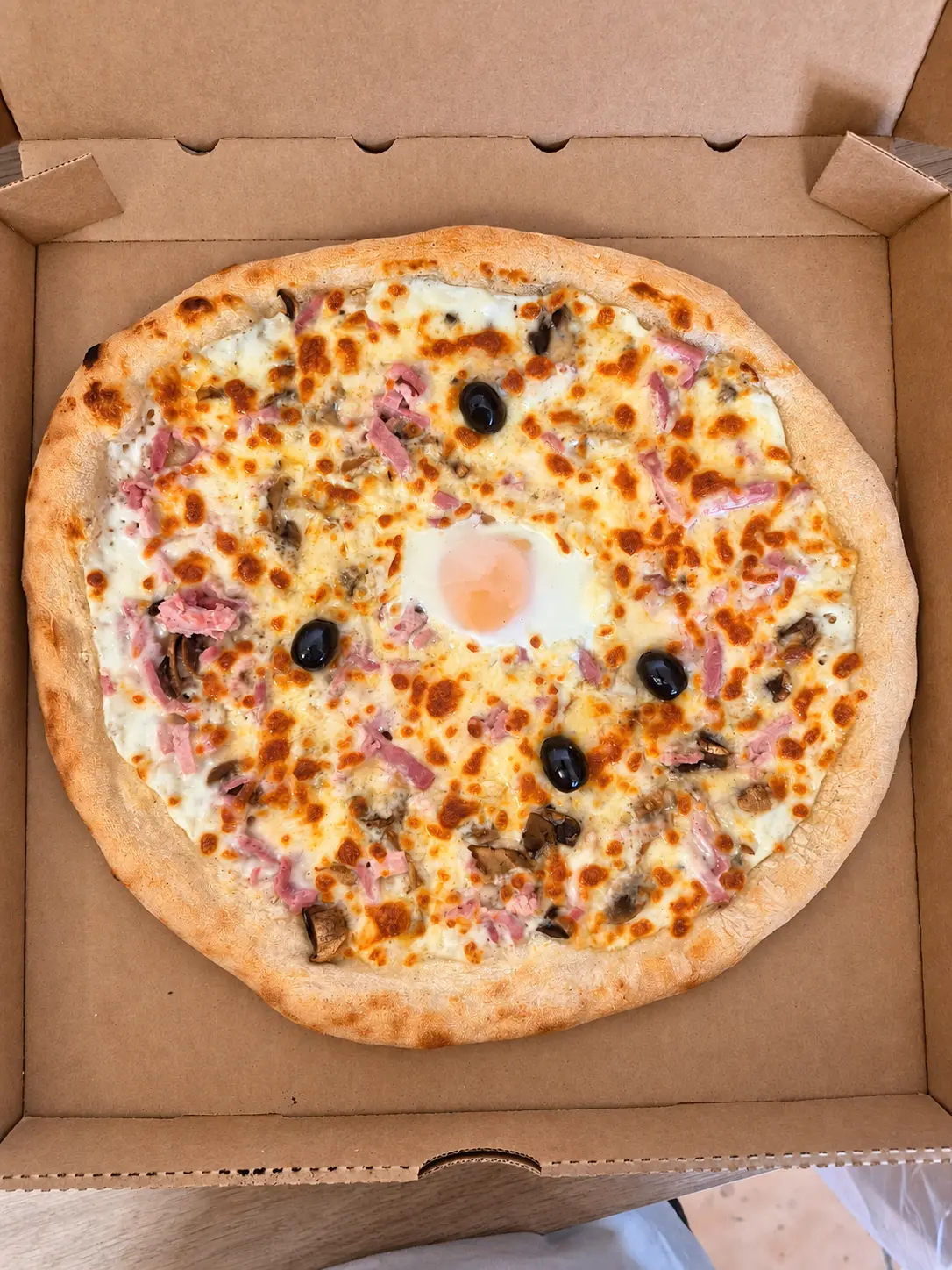 Pizza blanche maison avec œuf, jambon, champignons et olives